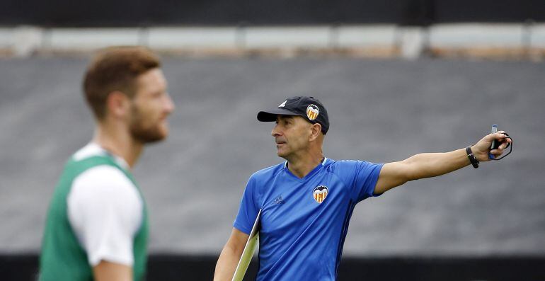 El entrenador del Valencia, Pako Ayestarán, y el jugador alemán Mustafi (i), durante un entrenamiento