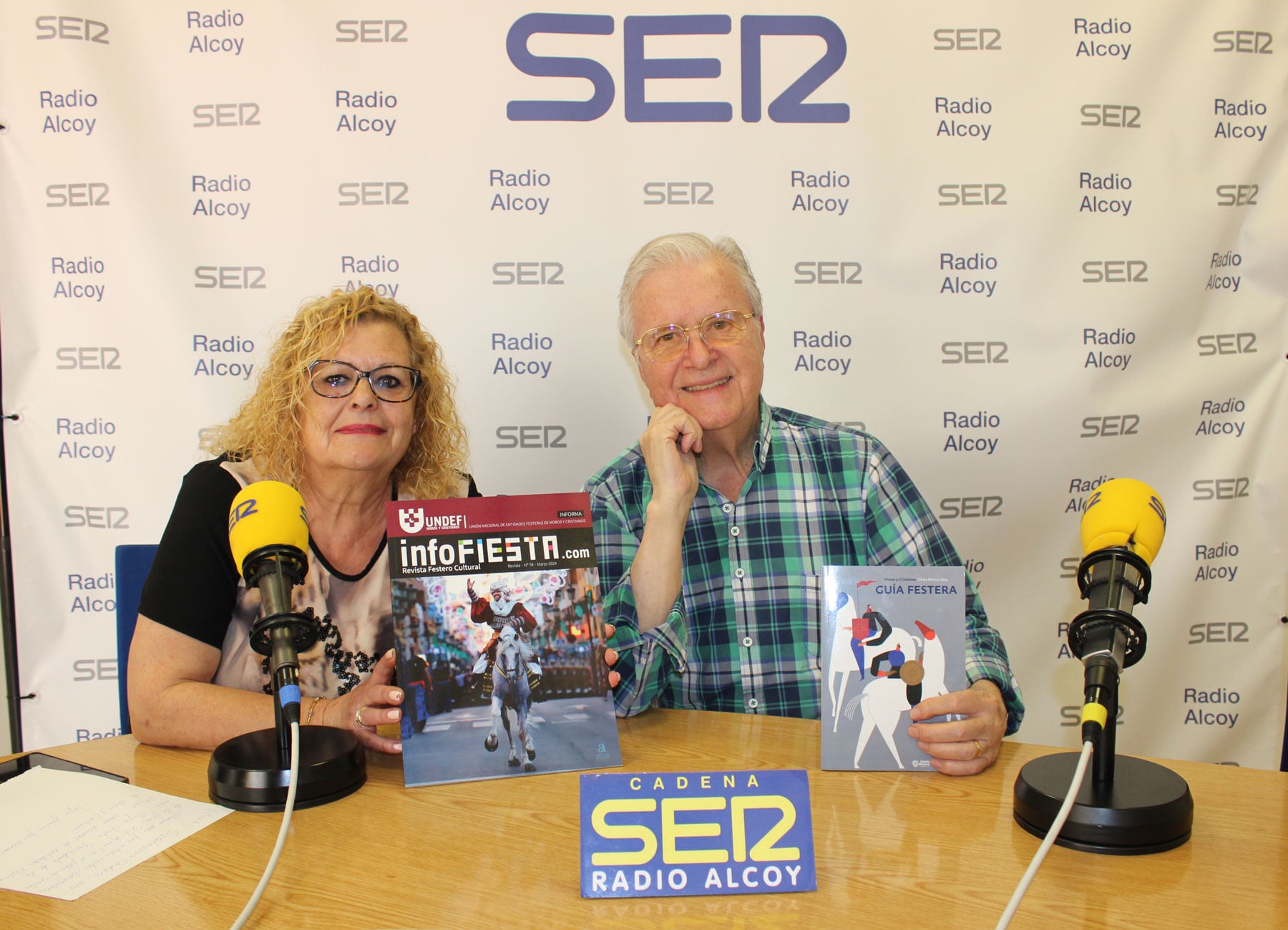 Pepa Prats y Paco Aznar, en el estudio central de Radio Alcoy, sostienen publicaciones editadas por la UNDEF