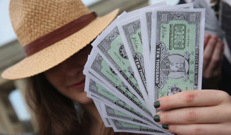 Un activista viste un sombrero panameño y sostiene billetes falsos durante una manifestación contra los paraísos fiscales en Berlín.