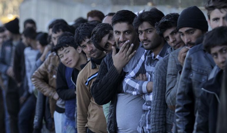 Varios refugiados hacen cola para recibir alimentos en el centro de recepción de Moria en la isla de Lesbos, Grecia 