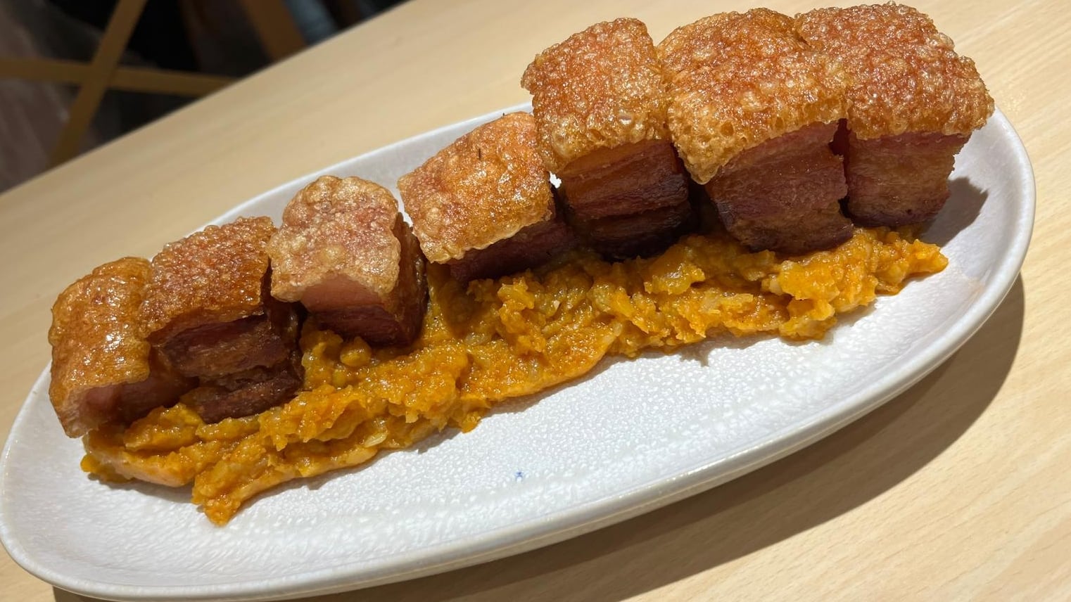 Plato de torrezno sobre patatas revolconas de el restaurante &#039;El Quillo&#039;.