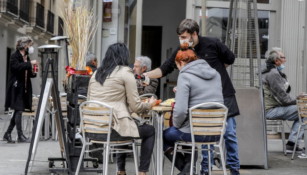 Archivo - Un camarero atiende a dos clientas en una terraza el primer día de la apertura de la hostelería
