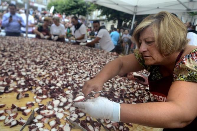 Una pulpeira durante la elaboración de la tapa gigante de &quot;pulpo á feira&quot; preparada este martes en la plaza mayor de O Carballiño (Ourense).