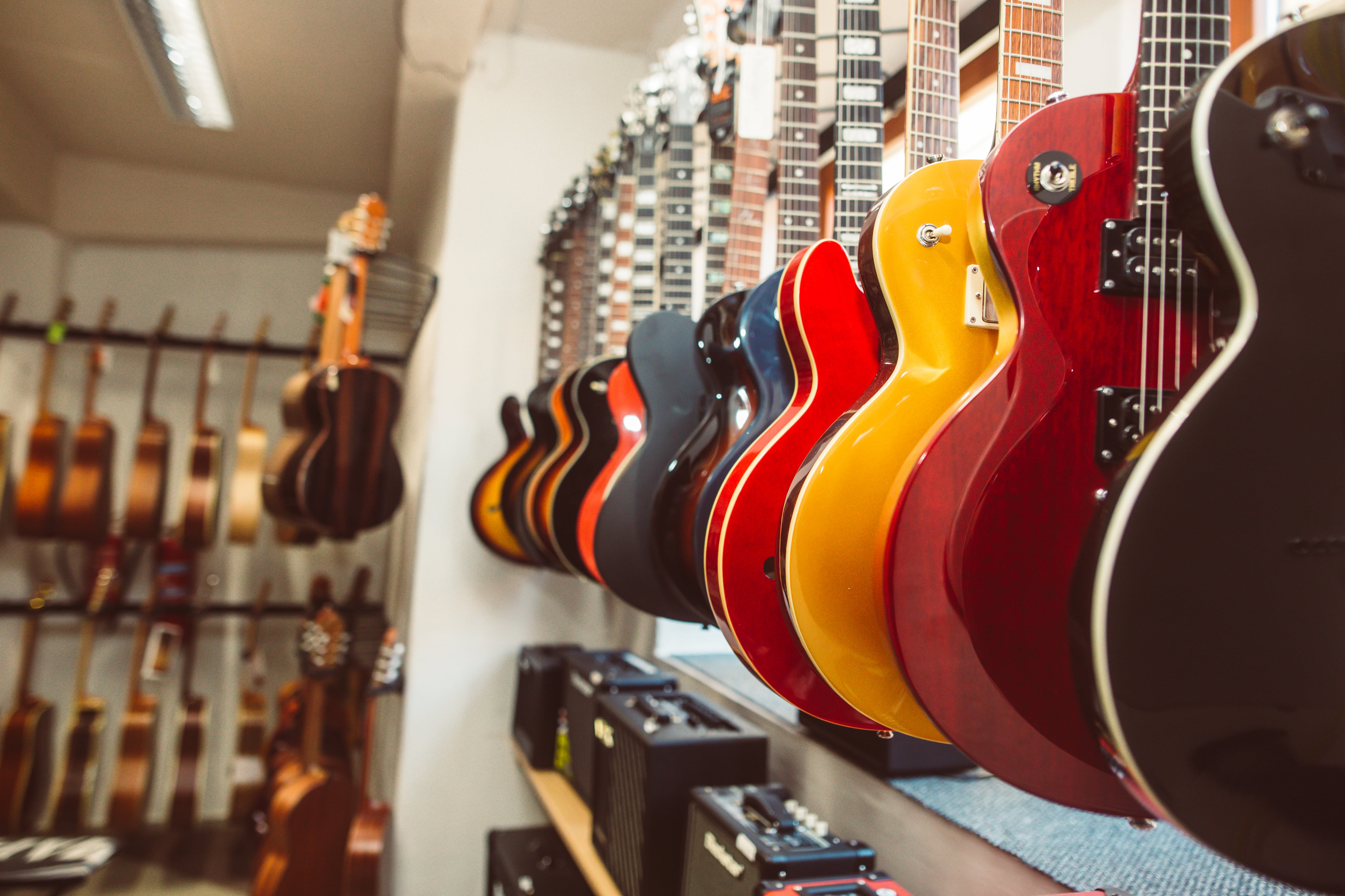 Close up of electric guitars in a row in huge instrument shop