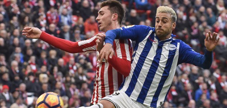 El centrocampista del Deportivo Alavés, Víctor Camarasa (d), intenta controlar el balón ante el defensa francés del Athletic Club, Aymeric Laporte (i), durante el partido de la decimoséptima jornada de Liga de Primera División disputado esta mañana en el 