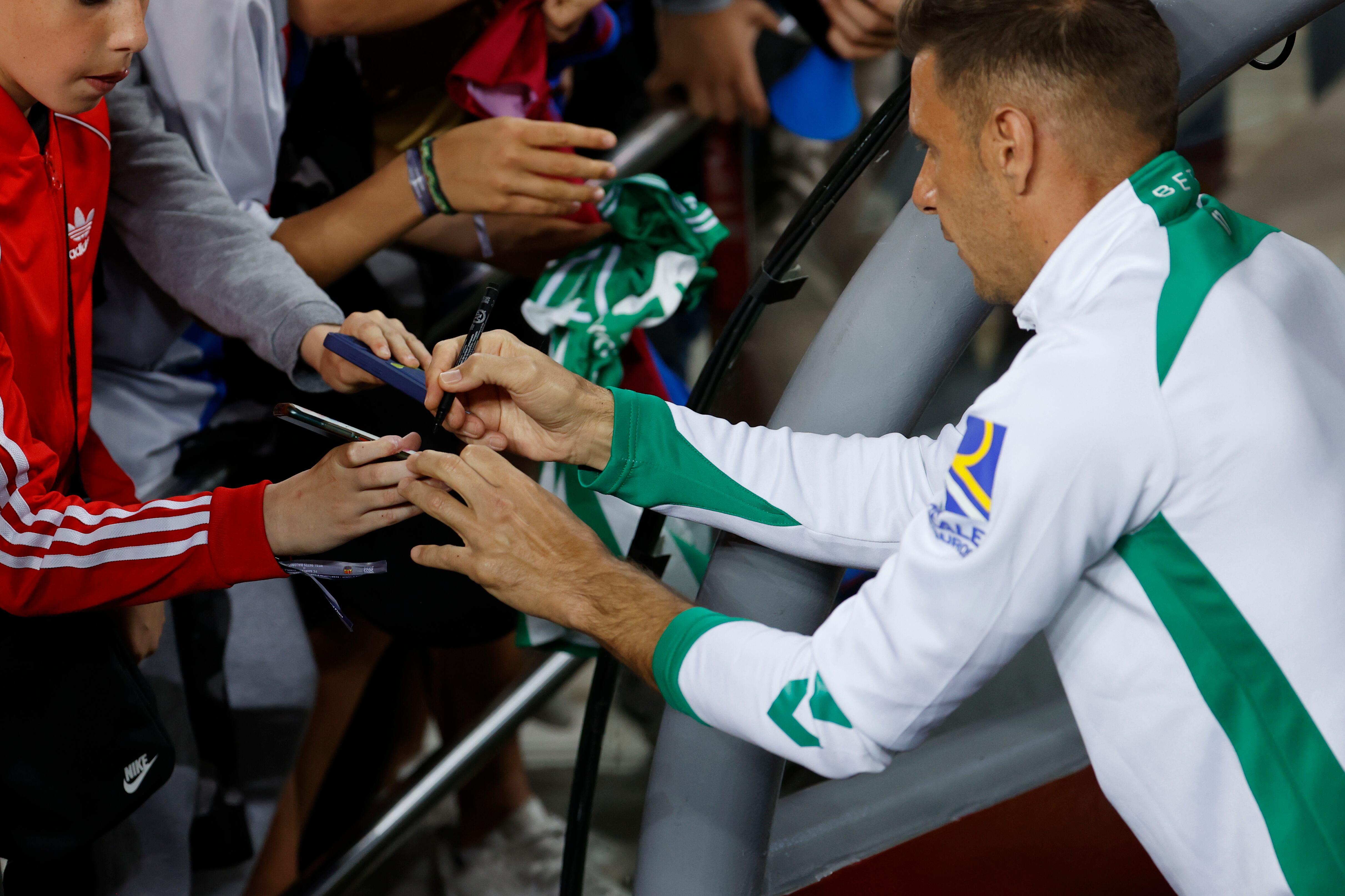 El centrocampista del Betis Joaquín Sánchez firma autógrafos a sus admiradores durante el partido de la jornada 32 de LaLiga Santander que enfrentó al FC Barcelona y al Real Betis en el Spotify Camp Nou de la Ciudad Condal. EFE/ Toni Albir