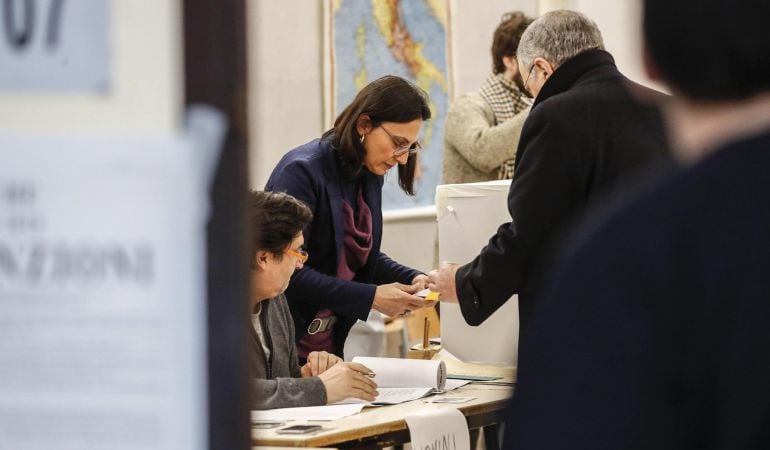 Un hombre deposita su voto en una urna durante las elecciones generales en Roma.