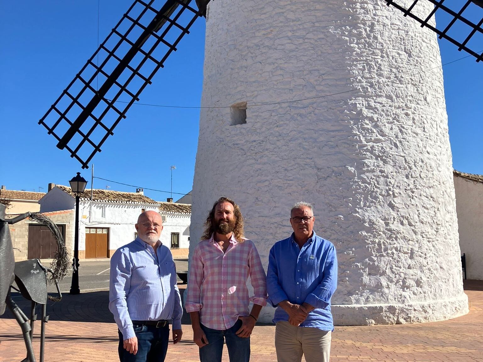 Juan Bautista, carpintero molinero (en medio), junto con el delegado provincial de la Junta en Albacete, Pedro Antonio Ruiz Santos (izquierda) y el alcalde de Munera, Desiderio Martínez (Derecha). De fondo, &#039;La Molineta&#039; de Munera