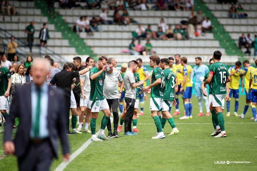 Jugadores de Racing y Cádiz, en el campo de A Malata durante el parón en el partido de este domingo, debido al desmayo de una aficionado (foto: LaLiga Hypermotion)