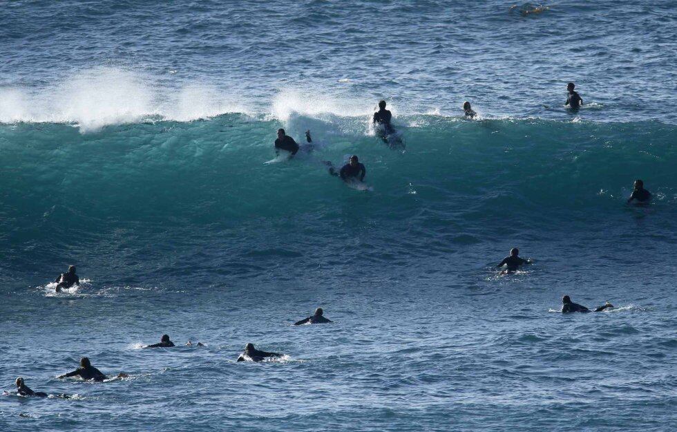 Un grupo de surferos esperando a la ola adecuada