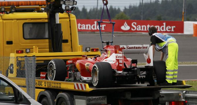 El Ferrari F138 de Fernando Alonso es retirado por una grúa