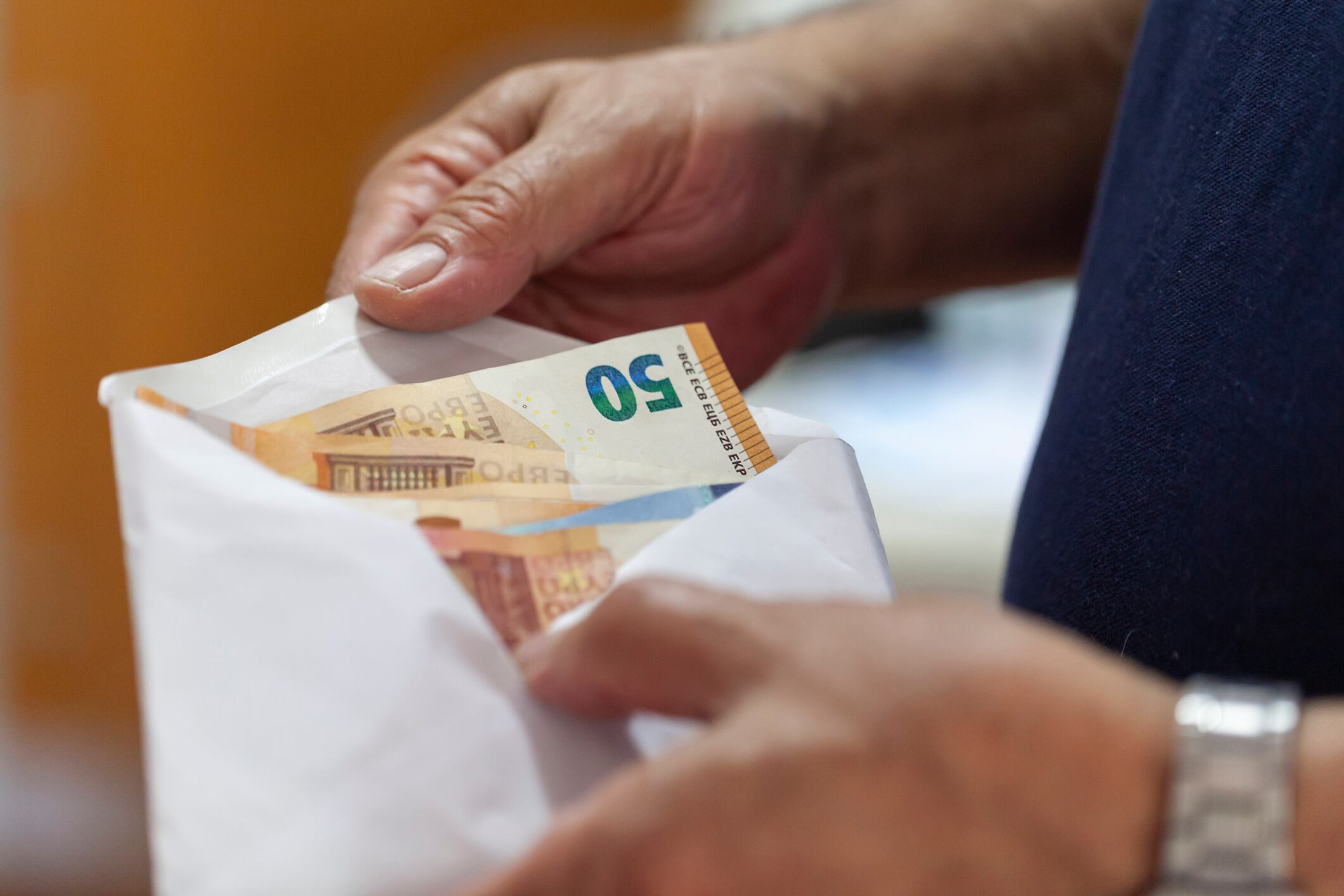 Una persona consulta un sobre con dinero dentro.