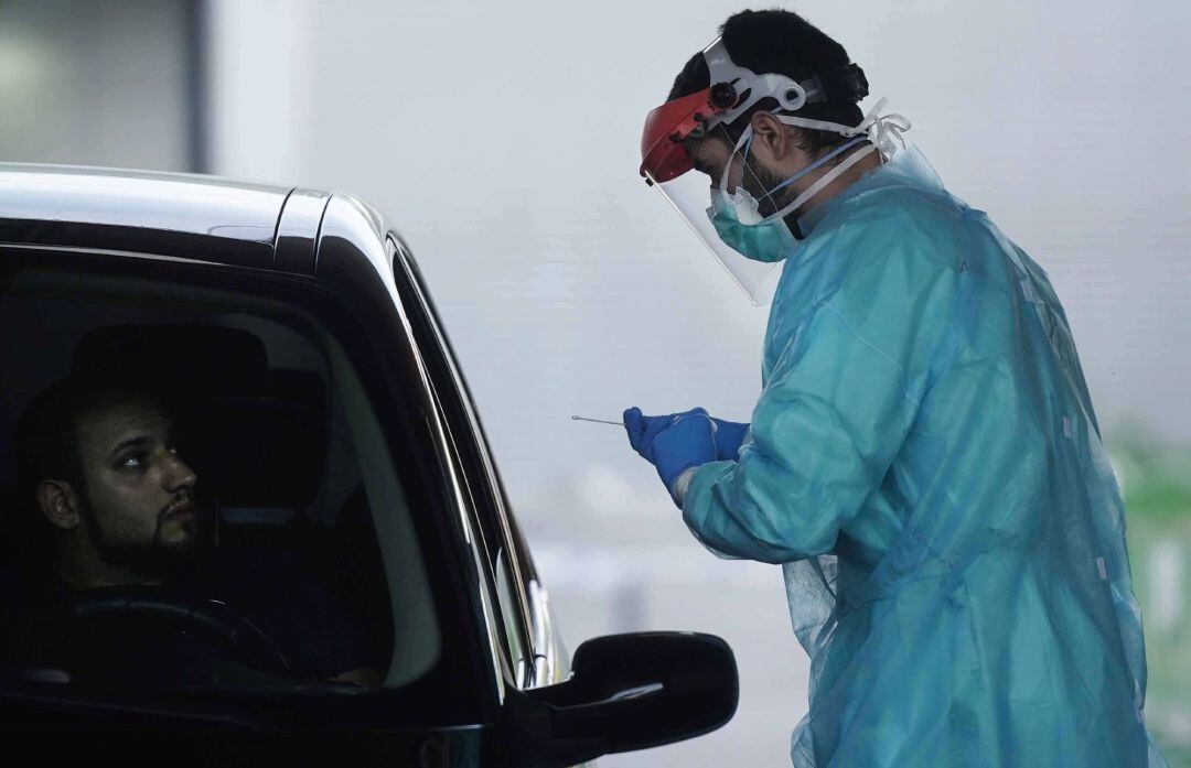 Un sanitario realiza un test PCR a una de las personas citadas en una de las carpas instaladas en los alrededores de la zona del centro sanitario Carlos Castilla del Pino de Córdoba