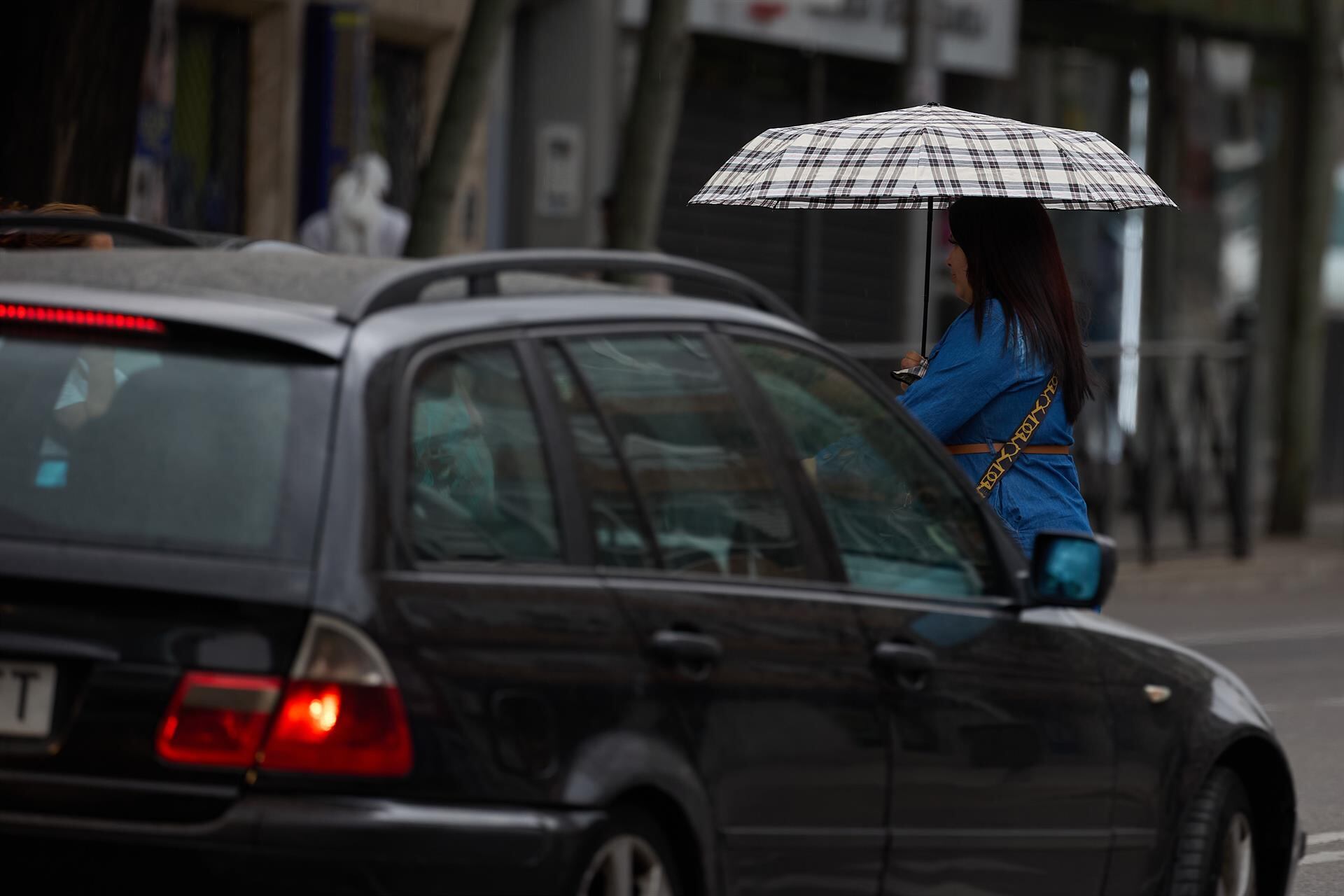 Archivo - Una mujer se protege de la lluvia con un paraguas -