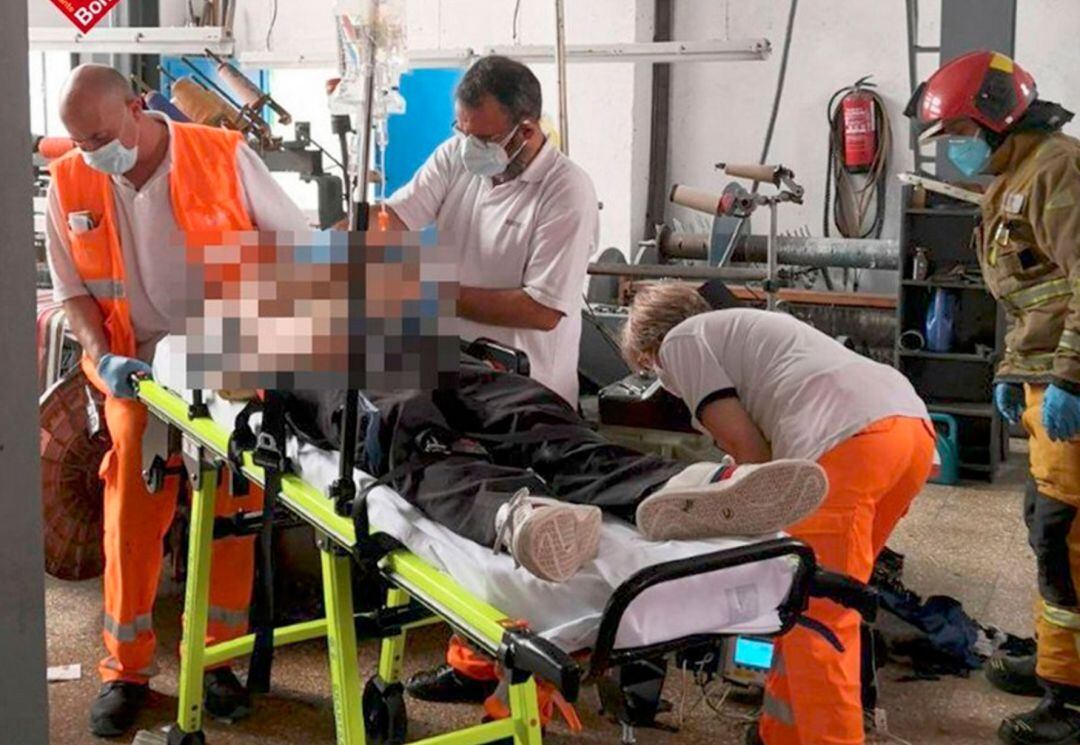 Los sanitarios y bomberos atendiendo al herido en el accidente laboral en Alcoy.