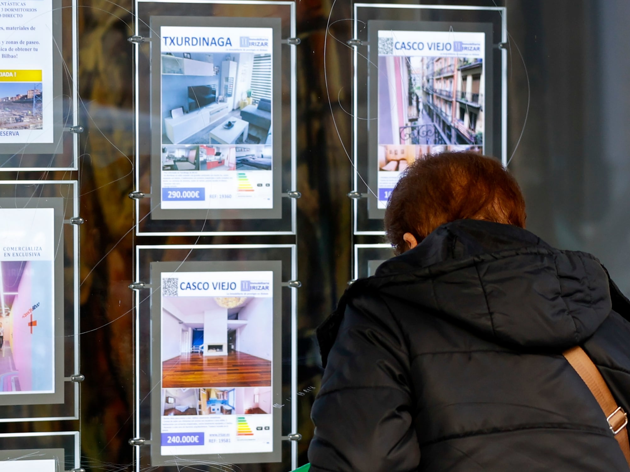 Una mujer observa en una inmobiliaria la oferta de viviendas