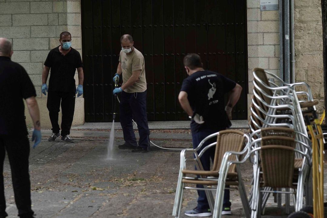 Unos camareros limpian la terraza de un bar del casco antiguo de Córdoba
