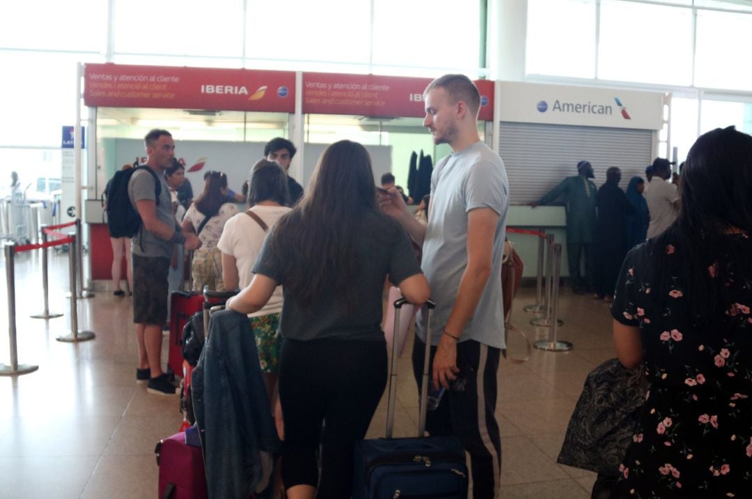 Plano general de varios pasajeros en el punto de reclamaciones de Ibreria en el aeropuerto de El Prat.