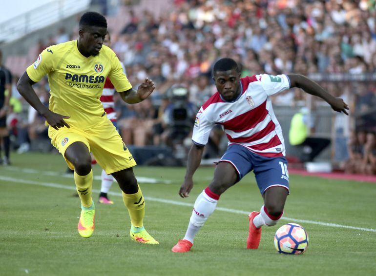 El centrocampista del Granada Jeremie Boga pelea un balón con el centrocampista del Villarreal Alfred N&#039;Diaye durante el partido correspondiente a la primera jornada de Liga que ambos equipos disputan en el estadio de Los Cármenes, en Granada.