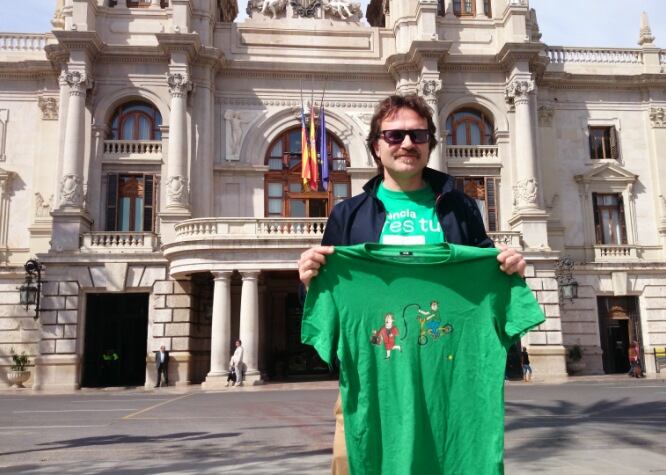 El asesor de Compromís, Giuseppe Grezzi, muestra la camiseta en cuestión frente al Ayuntamiento.