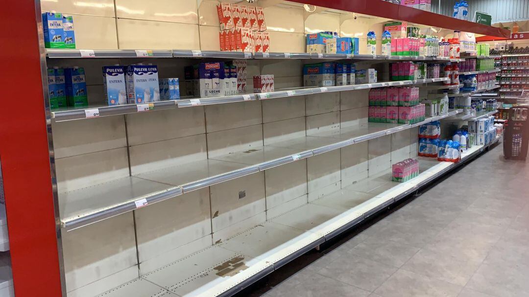 Estanterías medio vacías en un supermercado Deza tras la avalancha de público después de decretarse la alerta por coronavirus