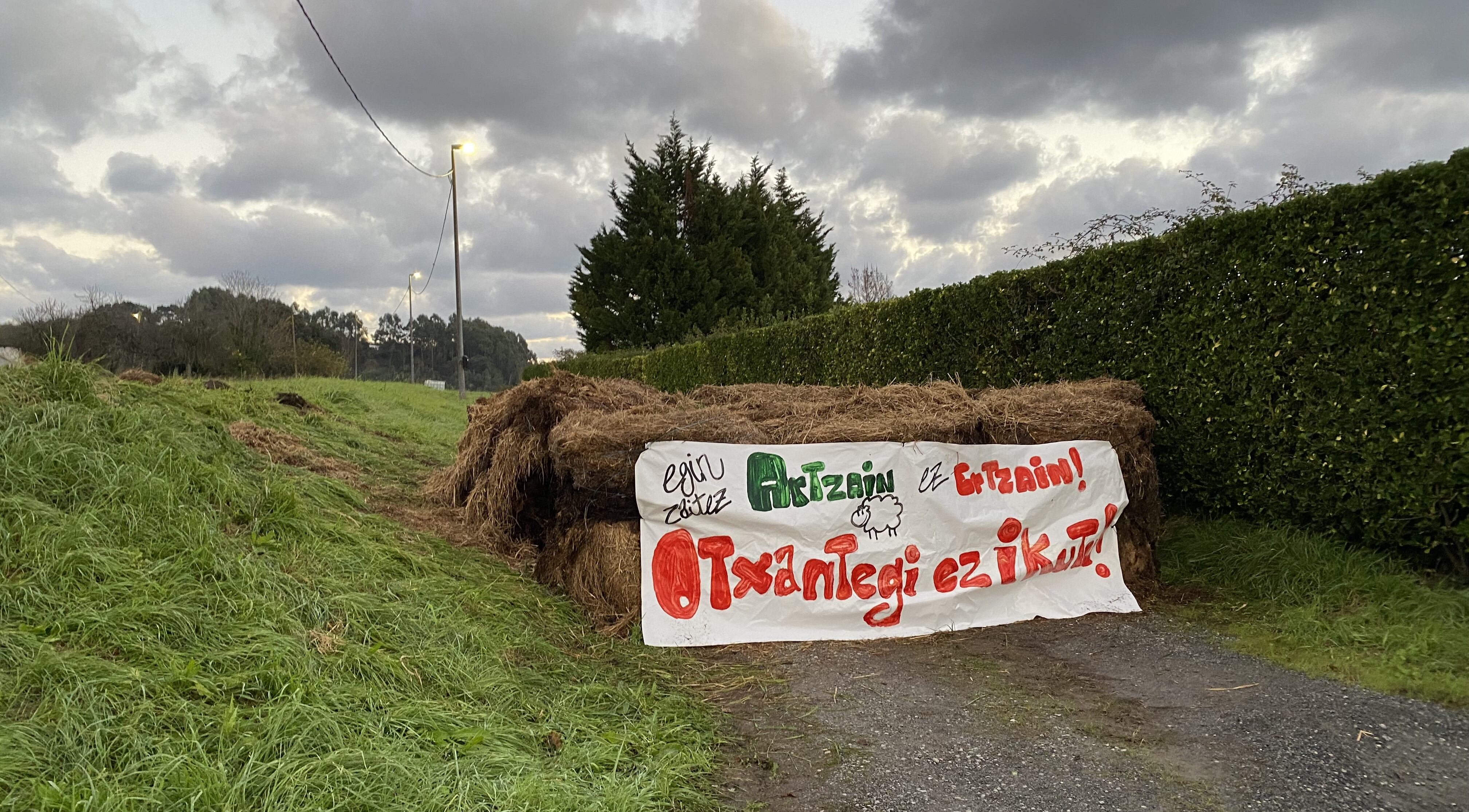 El acceso al caserío Otxantegi bloqueado por fardos de paja.