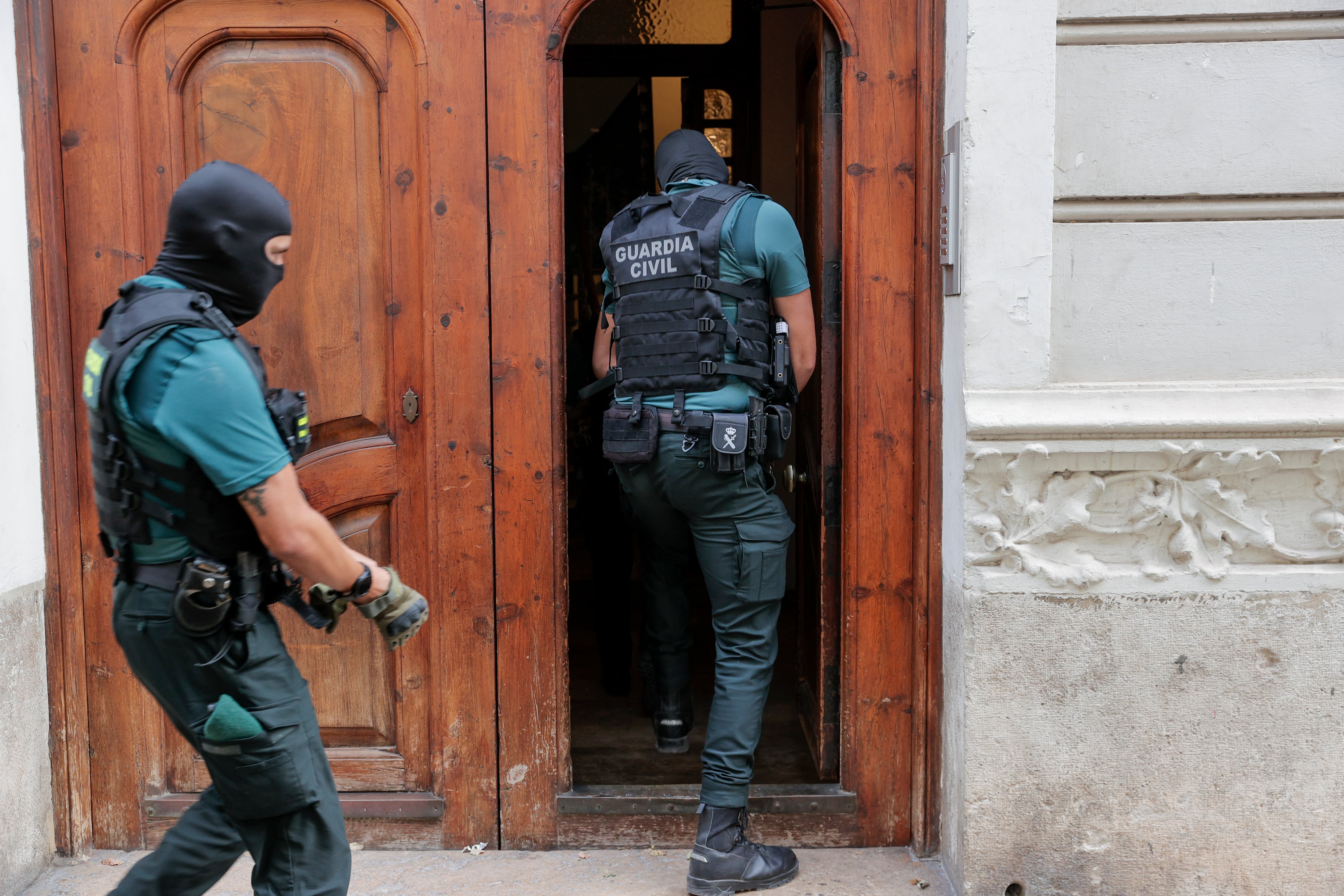 GRAFCVA6299. VALENCIA, 16/10/2023.- Dos agentes de la Guardia Civil acceden a un edificio durante el desarrollo este lunes por parte de la Comandancia Provincial de Valencia de una operación a gran escala, con registros y detenciones en diversos puntos de la provincia, contra una supuesta red de dedicada al robo organizado. EFE/Manuel Bruque
