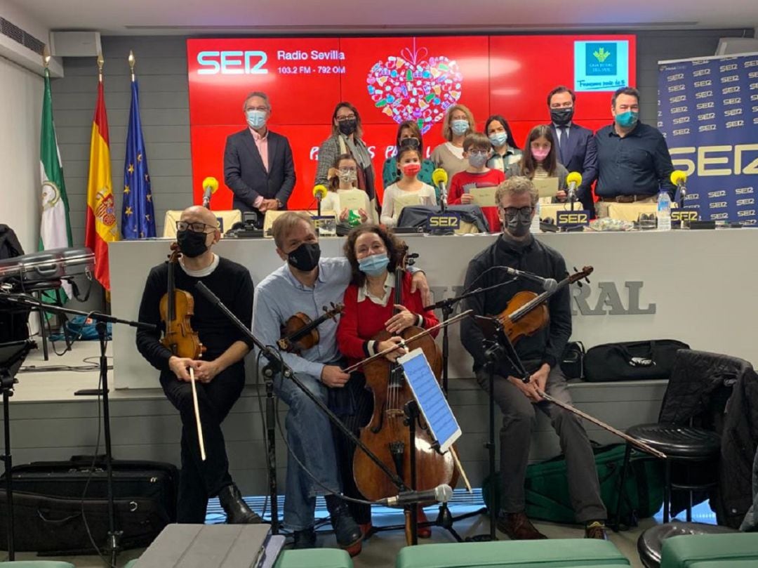 Foto de familia de los niños ganadores del concurso junto a las lectoras de sus cuentos, los profesores de la ROSS (en primer término), Alejandro González Tineo, responsable de Negocio Internacional de Caja Rural del Sur, segundo por la derecha; y Rafa Almarcha, primero por la derecha