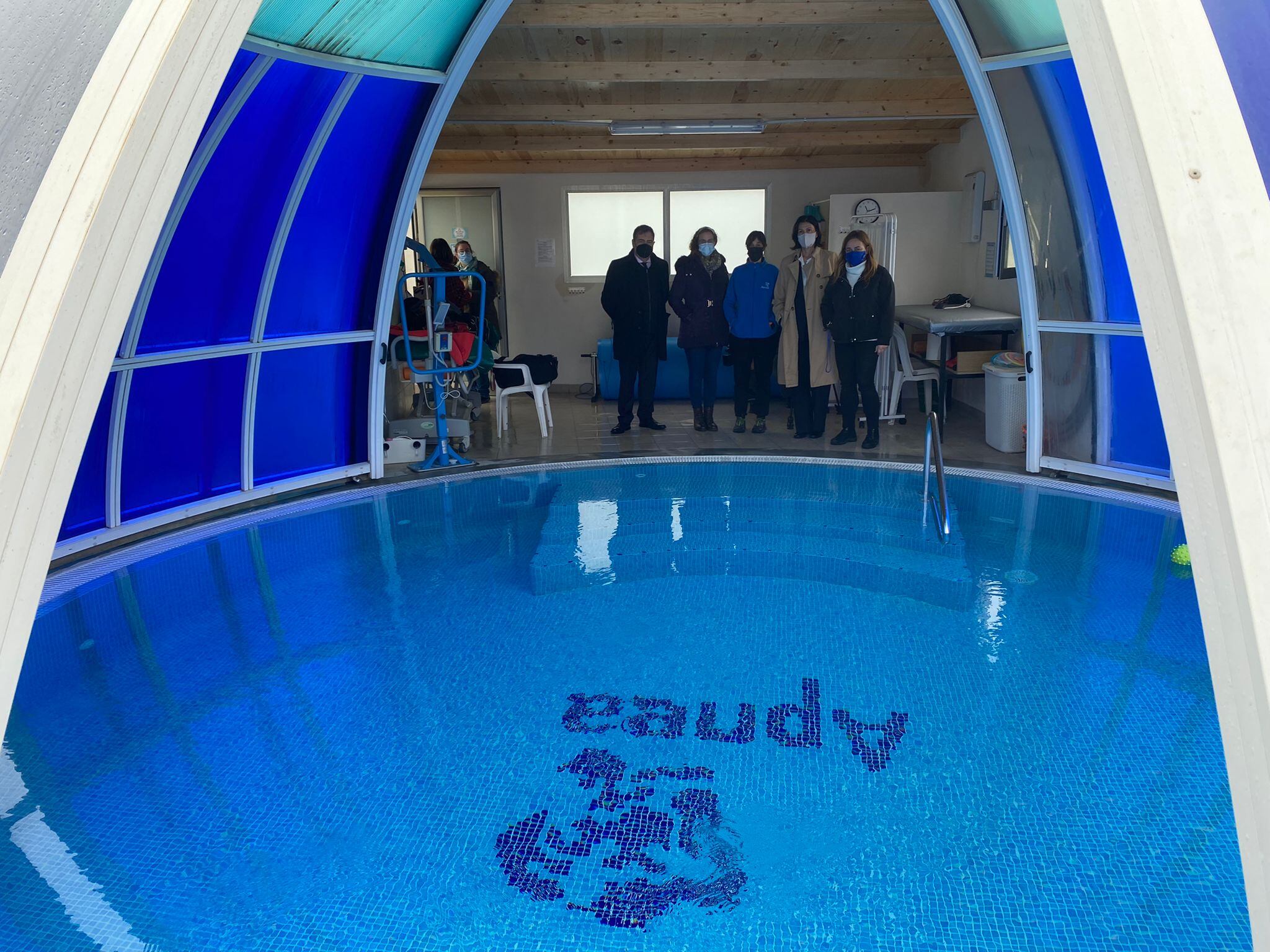 Paloma López, presidenta (primera por la derecha) con el responsable de comunicación de Vectalia ante la piscina terapéutica