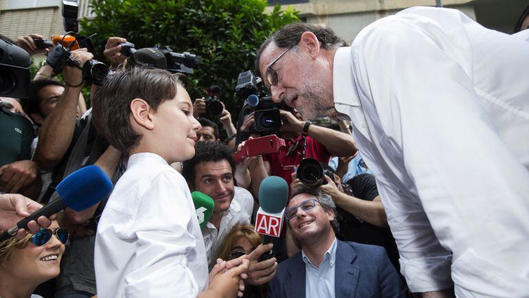 El presidente del Gobierno en funciones y presidente del PP, Mariano Rajoy (d) durante el encuentro que mantenido con el niño que participó en el programa de televisión de Telecinco, &quot; 26J Quiero Gobernar&quot;