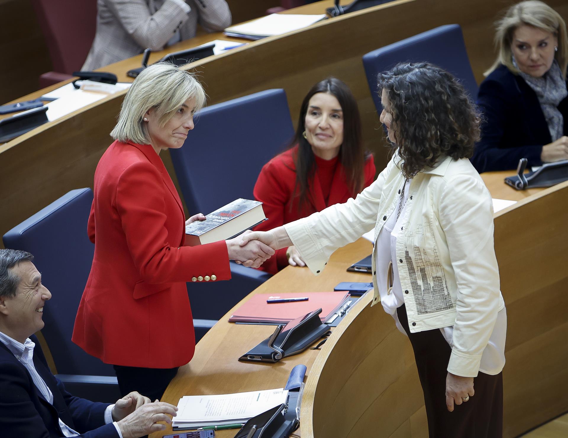 Mercedes Caballero le entrega un libro a Elisa Núñez