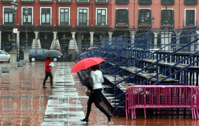 Los ciudadanos se refugian de la lluvia mientras las tribunas de la Semana Santa permanecen vacías