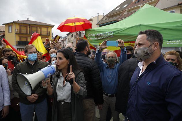 La candidata de Vox a la Presidencia de Madrid, Rocío Monasterio interviene con un megáfono y el líder nacional del partido y director de campaña, Santiago Abascal en Cercedilla