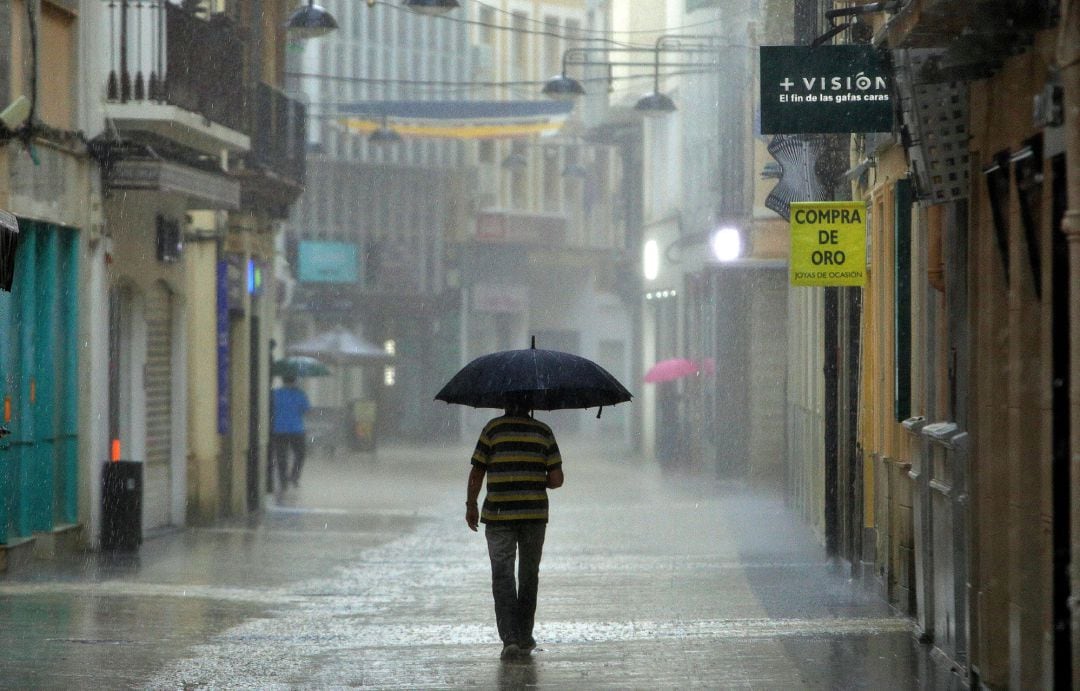 Un hombre camina, este lunes, bajo una intensa lluvia por el centro de la ciudad de Gandía. Según la Agencia Estatal de Meteorología (Aemet), la situación meteorológica a las 9 de esta mañana era de tormentas casi generalizadas en la provincia de Valencia