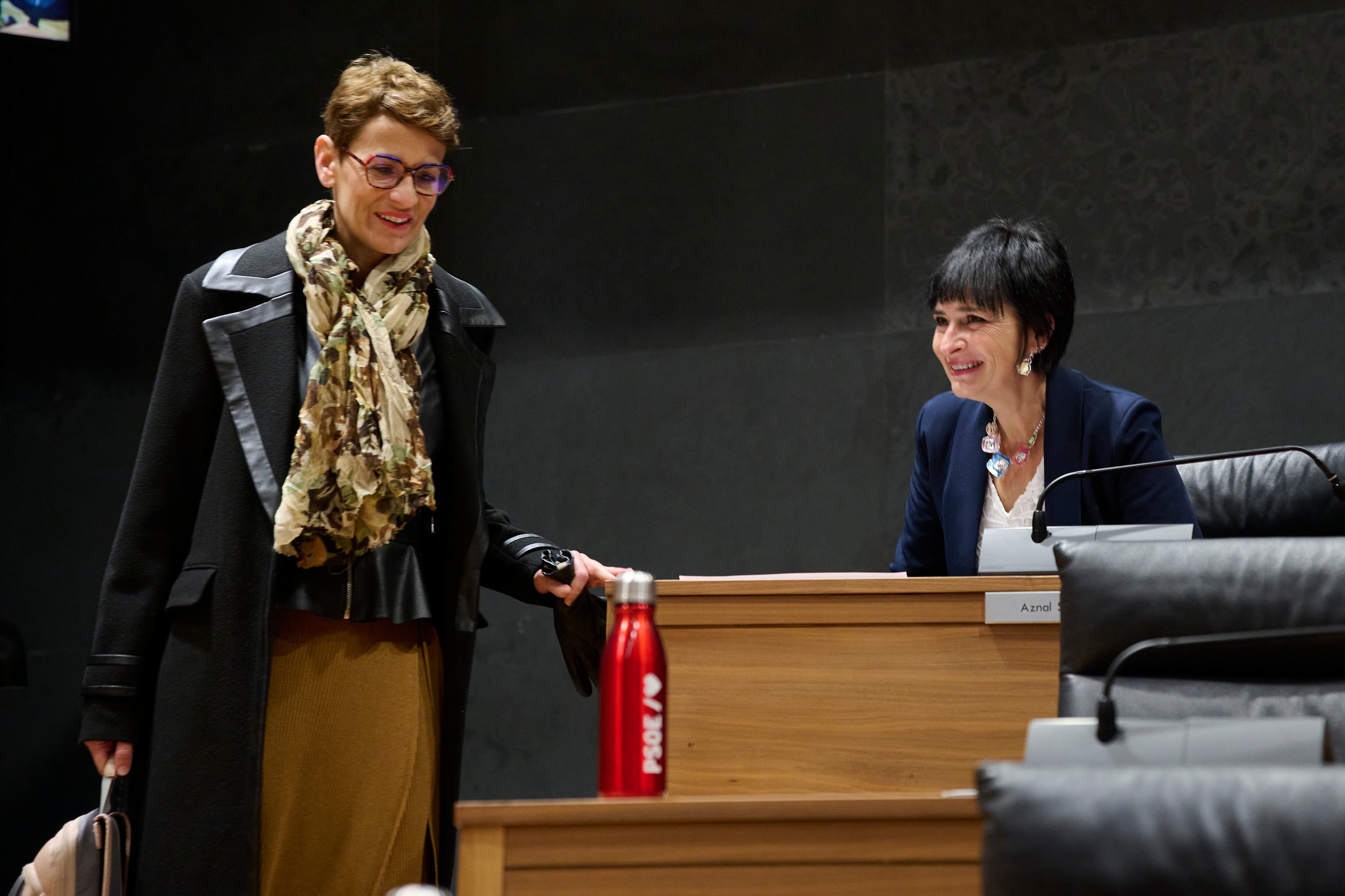 La presidenta del Gobierno de Navarra, María Chivite (i), junto a la parlamentaria de EH Bildu, Laura Aznal (d), durante el Pleno del Parlamento donde este jueves se debaten los proyectos de ley de Presupuestos Generales para 2025 y de modificación de diversos impuestos y otras medidas tributarias