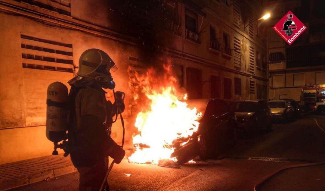 Bomberos apagando el fuego en un vehículo incendiado en Elda 