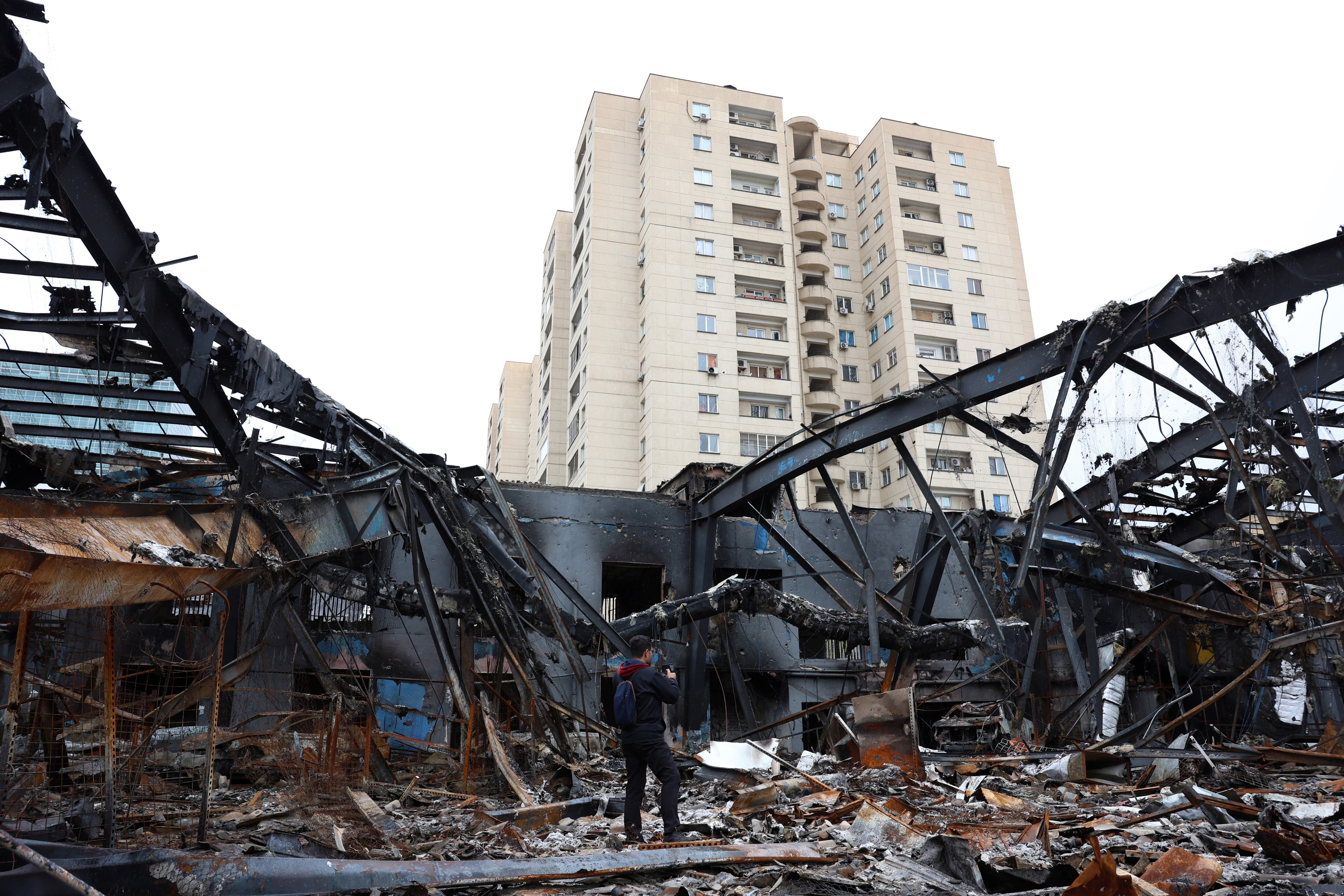 Periodistas trabajan entre los restos de vehículos en un taller de reparación de automóviles en Teherán, Irán, el 28 de marzo de 2026.