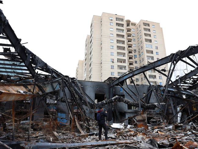 Periodistas trabajan entre los restos de vehículos en un taller de reparación de automóviles en Teherán, Irán, el 28 de marzo de 2026.