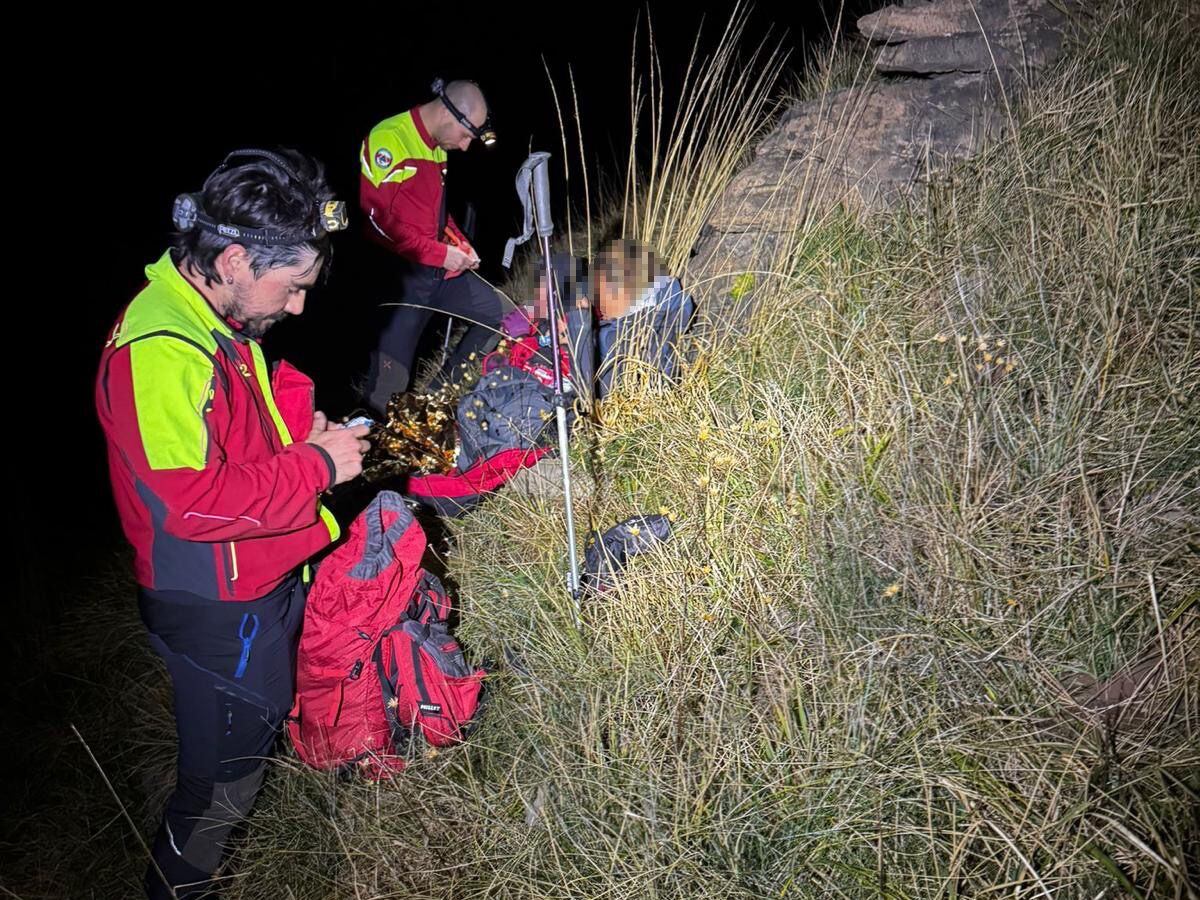 Técnicos de Protección Civil junto a las dos senderistas rescatadas.