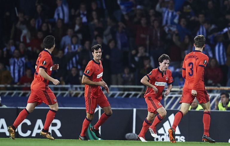 Los jugadores de la Real celebran un gol con la afición saltando en la grada detrás