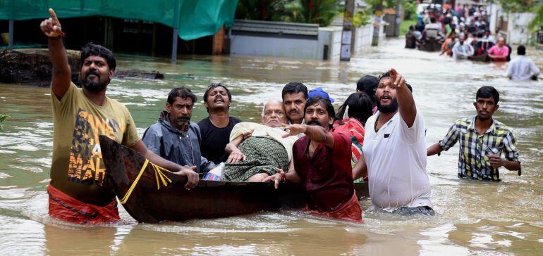 Un grupo de hombres evacua a un anciano en una barca durante las inundaciones sufridas en Kochi (India) hoy.