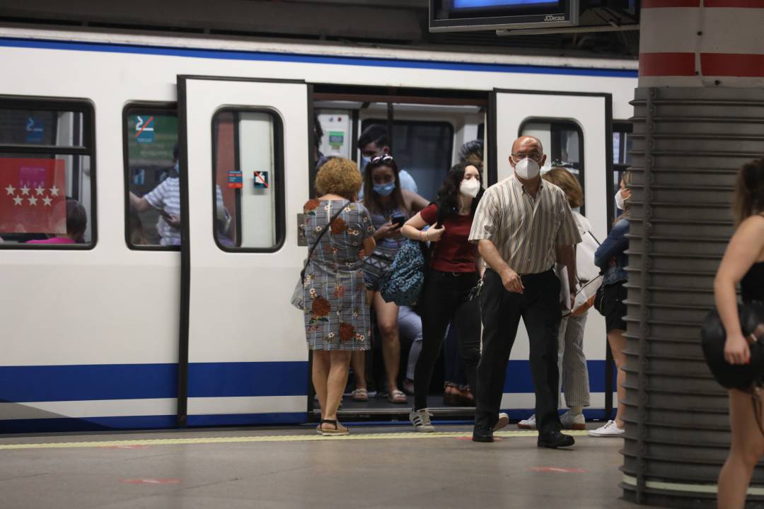 Pasajeros con mascarilla salen de un vagón en la estación de Metro de Atocha, en Madrid.