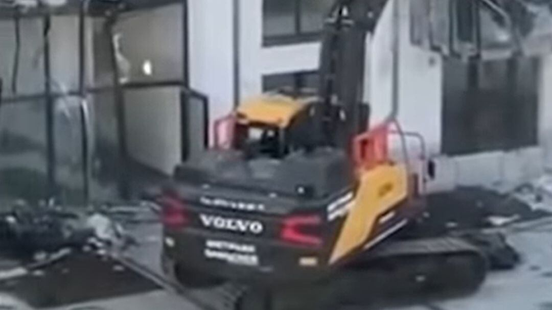 El contratista destruyendo el edificio con una retroexcavadora