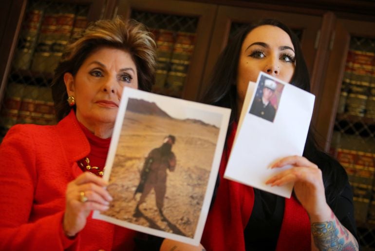 Attorney Gloria Allred (L) and former U.S. Marine Erika Butner hold up pictures of Butner as a Marine  following a press conference concerning their personal photographs being posted without their consent to a &quot;Marine Unit&quot; Facebook page in Los Angeles, C