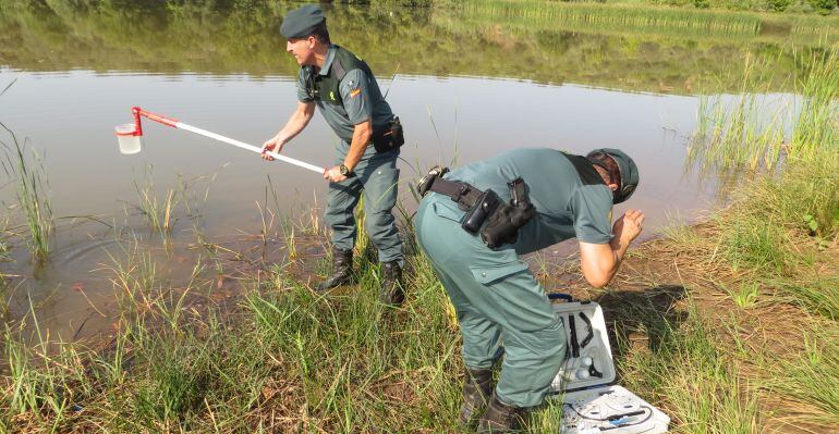 Dos guardias civiles cogen agua del río Rumblar para que sea analizada