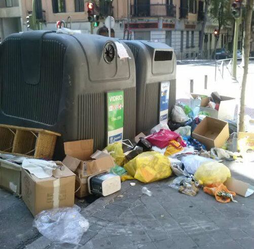 Imagen de unos contenedores rodeados de basura tirada por alrededor