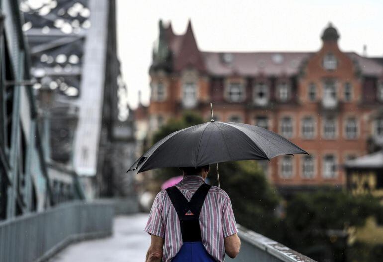 Un hombre cruza el puente de Loschwitz durante un día lluvioso Dresden