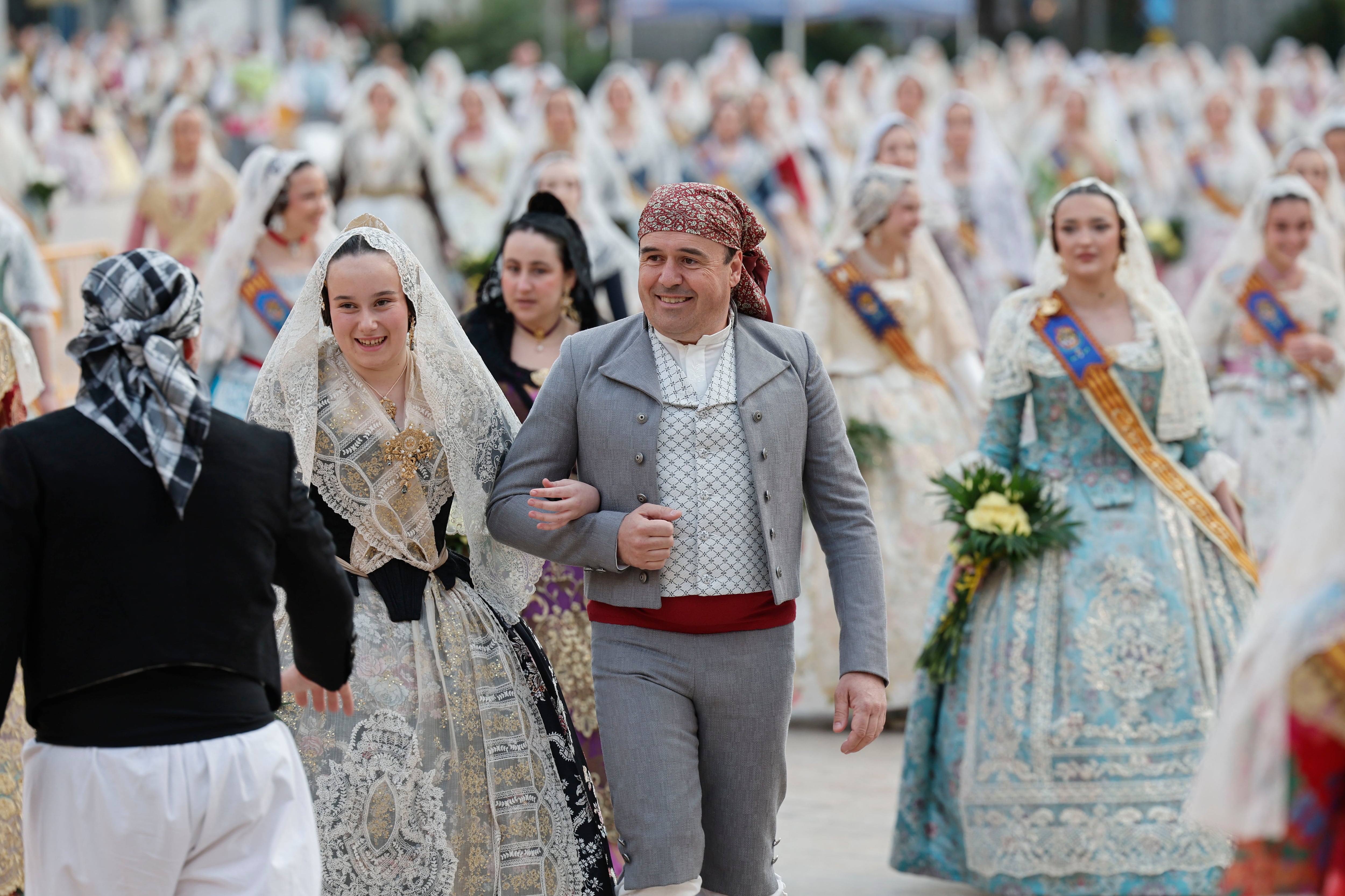 VALENCIA, 18/03/2026.- Una pareja de falleros desfila junto a varias falleras durante la segunda y última jornada de Ofrenda floral a la Virgen de los Desamparados, el acto religioso más multitudinario de las Fallas de València, por el que desfilan más de 100.000 falleras y falleros durante dos tardes y hasta la madrugada mientras la ciudad bulle, en ambiente soleado, con miles de turistas por sus calles.