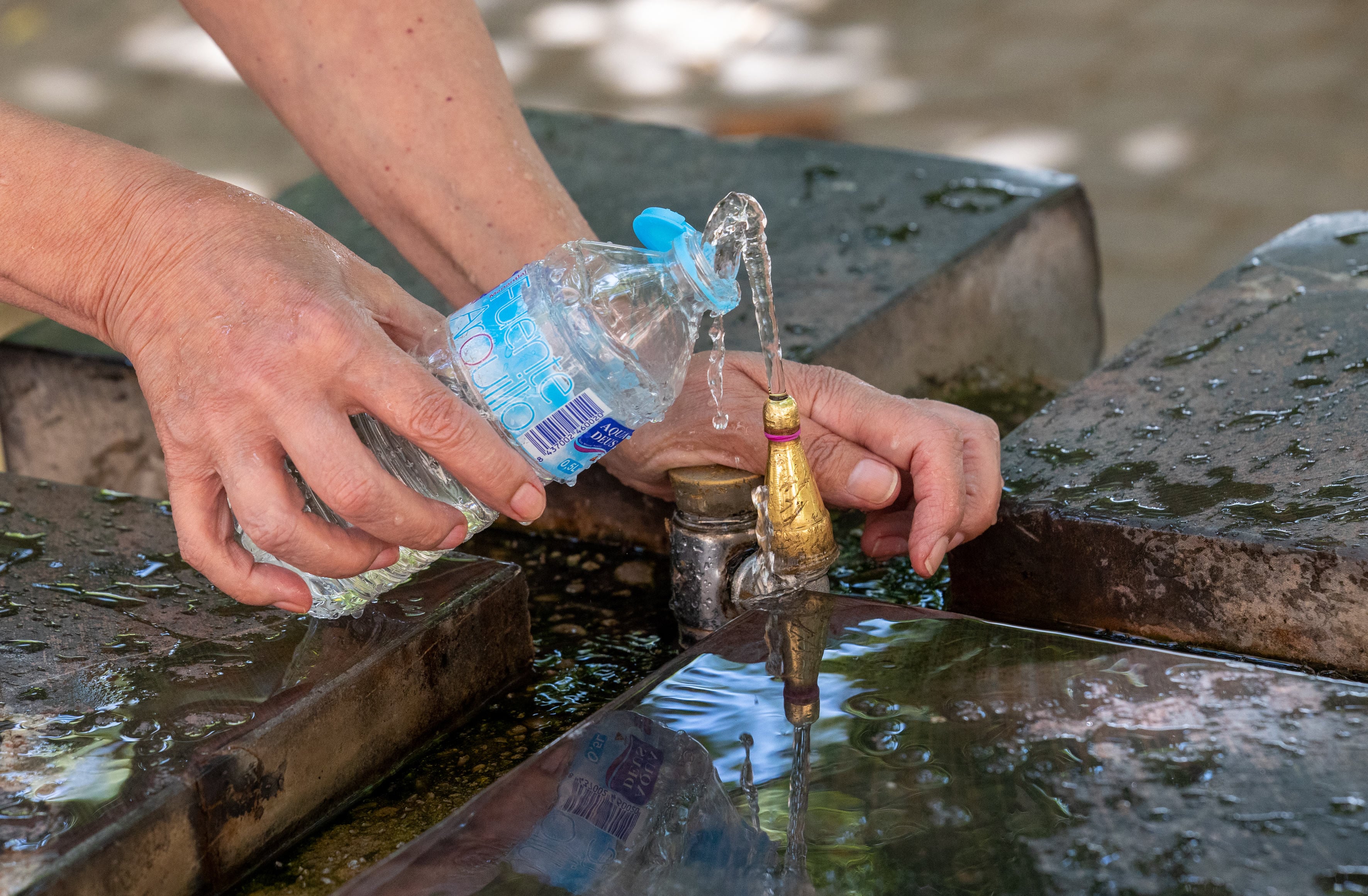 LOGROÑO, 09/07/2023.- Una mujer llena una botella de agua para referescarse por las altas temperaturas de 31 grados este domingo, en Logroño. La Agencia Estatal de Meteorología (Aemet) prevé para este domingo, en La Rioja, un ligero ascenso o sin cambios en las temperaturas mínimas, aunque las máximas descenderán ligeramente. EFE/Raquel Manzanares
