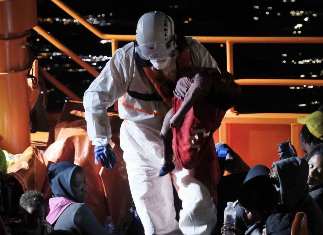 Un tripulante de Salvamento Marítimo desembarca en el muelle de Arguineguín a un bebé que llegó en parada cardíaca anoche tras ser recatado en una patera a cinco millas de Gran Canaria